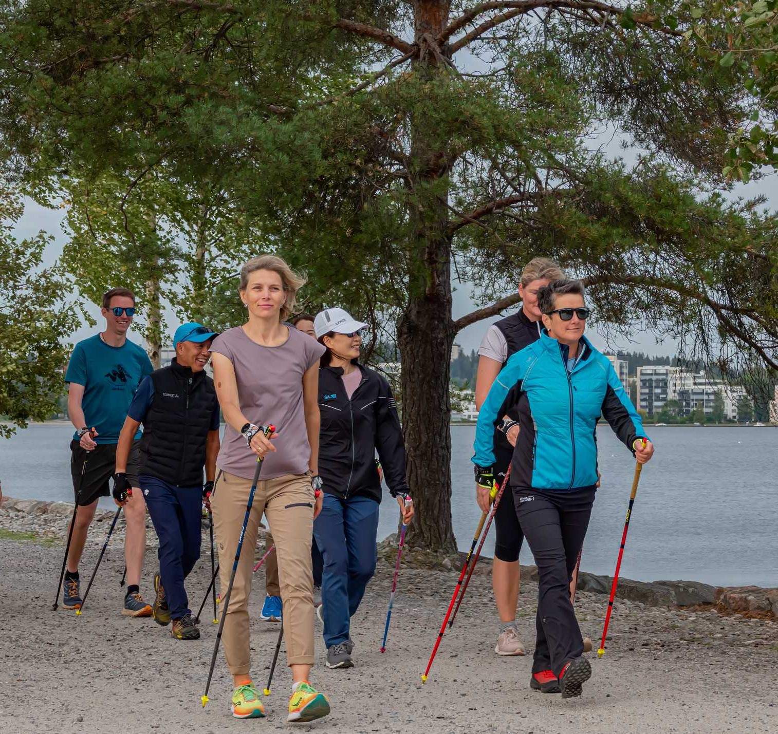 Two women Nordic Walking with poles along a park path